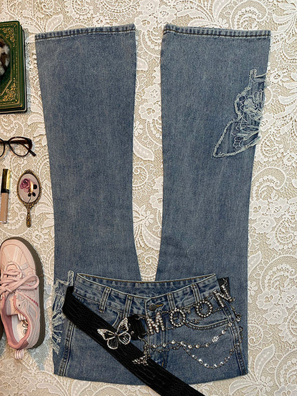 Light-blue micro-flare denim jeans with butterfly patches and black ribbon detail