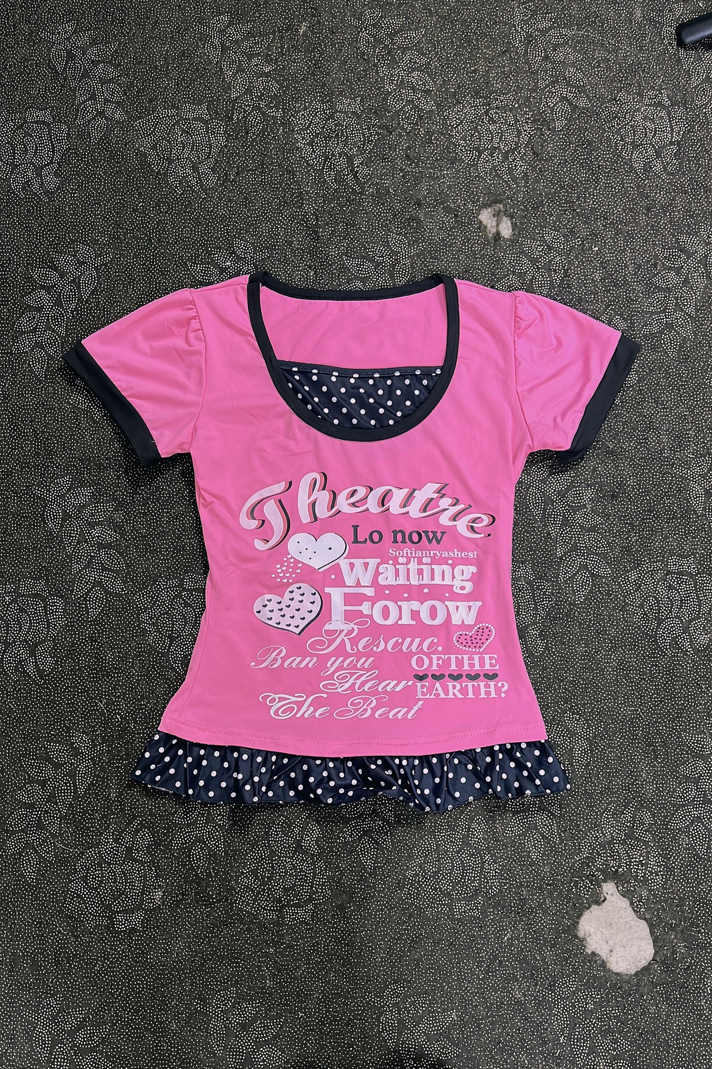 Pink T-shirt with black-trim neckline and polka-dot ruffle hem, heart letter graphic print