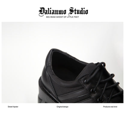 Black lace-up platform sneaker close-up with eyelets, striped panel, and thick sole