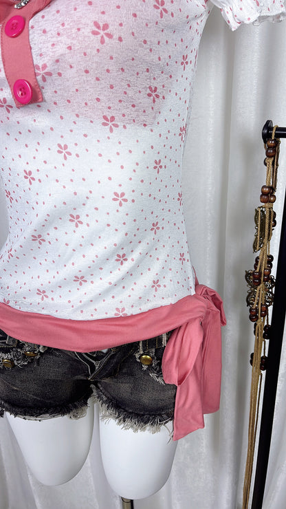Pink flower print top front with pink ruffle hem and buttoned placket