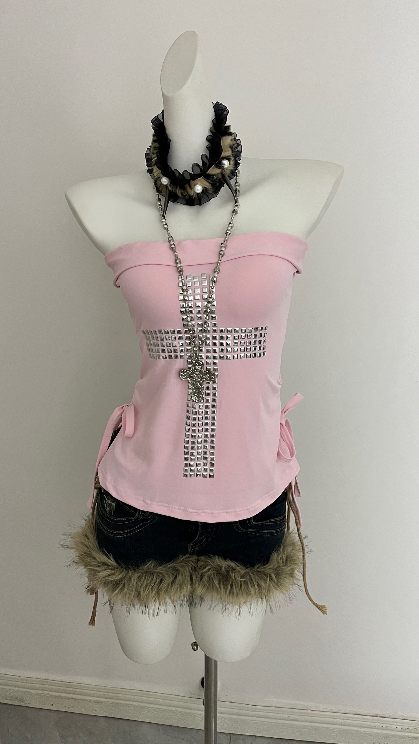 Pink strapless corset top with long rhinestone cross and tied side bows