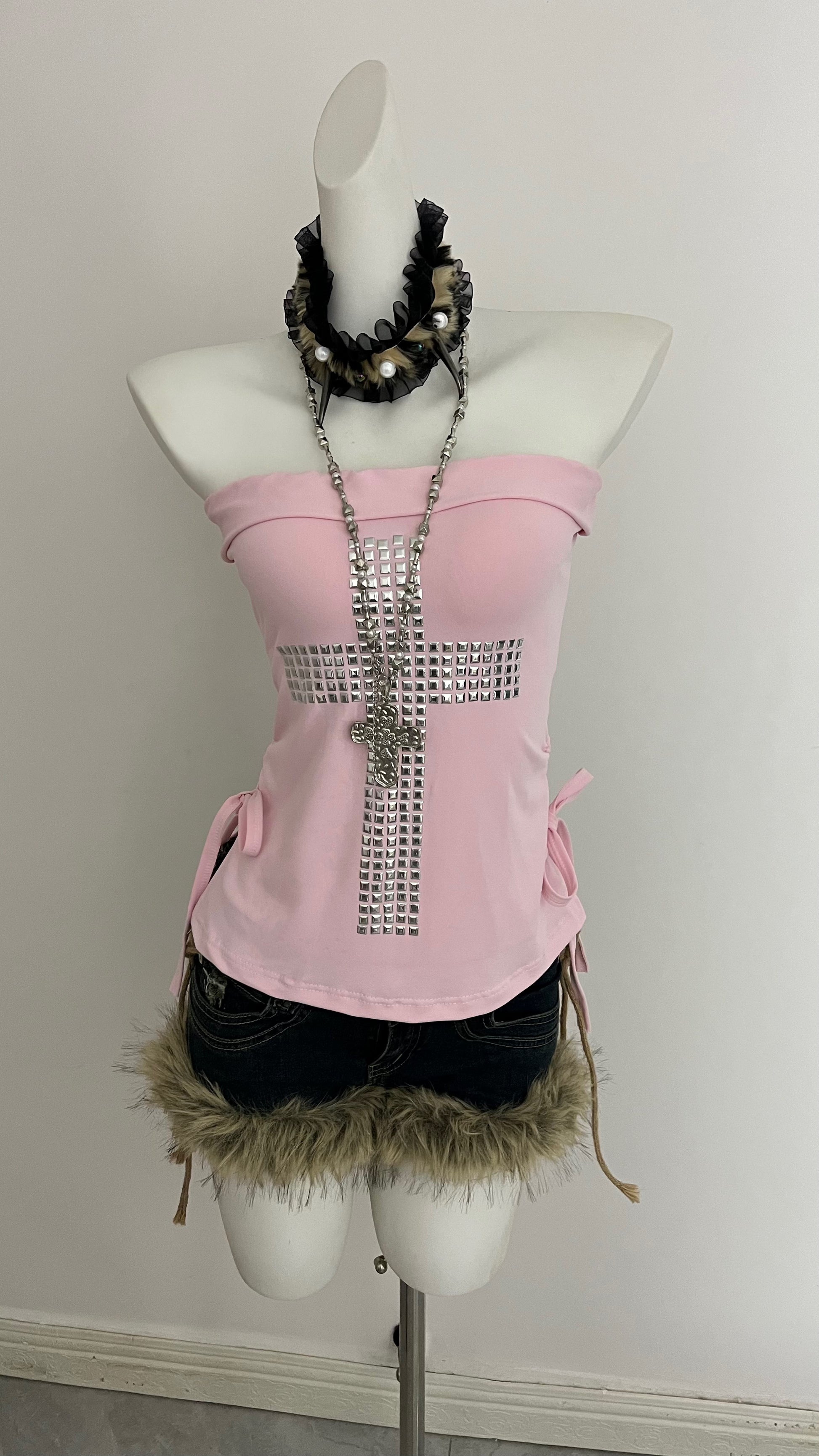 Pink strapless corset top with long rhinestone cross and tied side bows