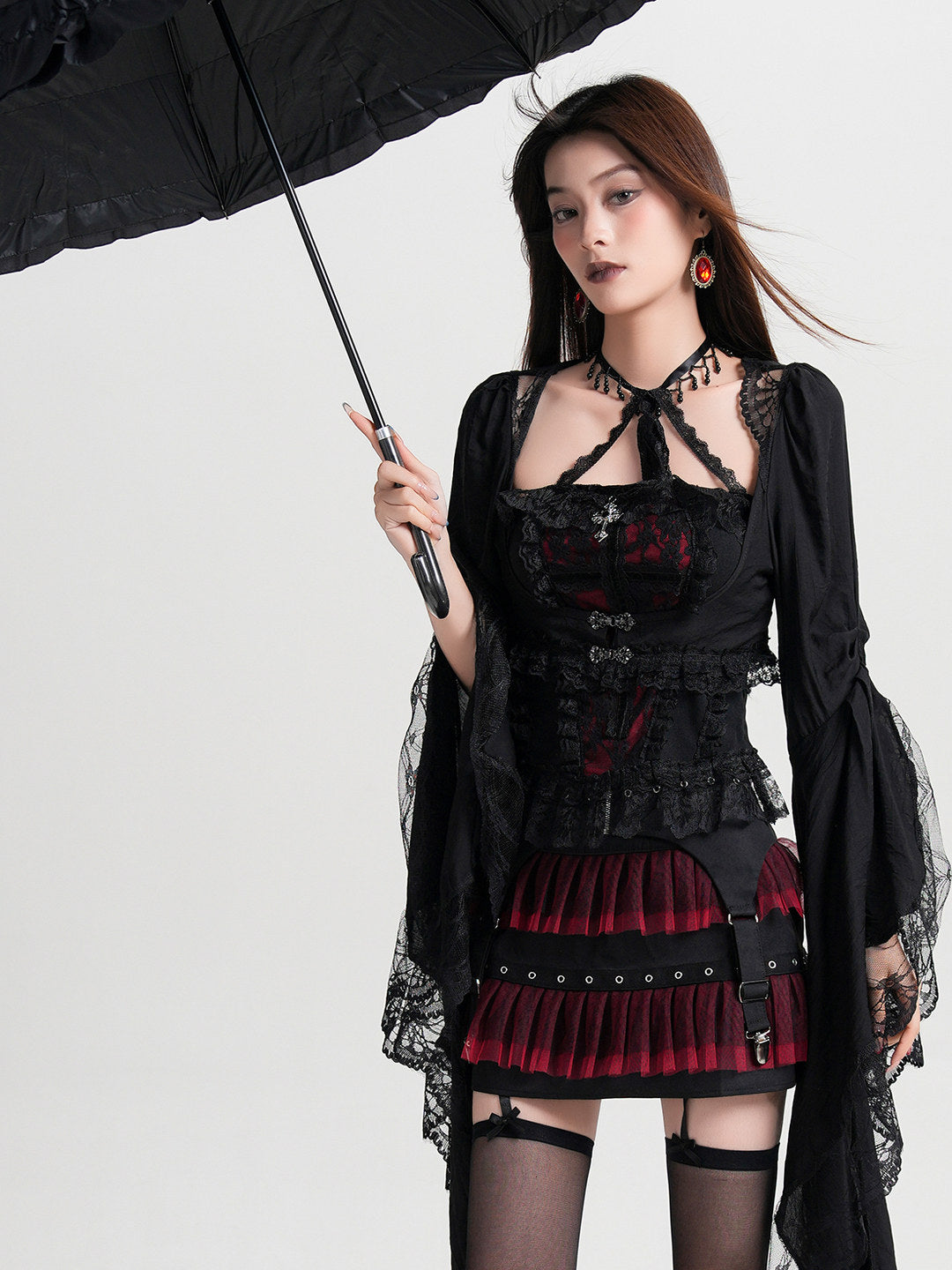 Black lace halterneck vest blouse with red panel and layered red ruffles at the hem.