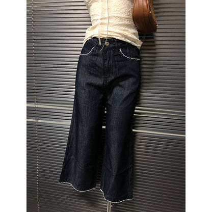 Dark blue slightly flared cropped jeans with button closure and scalloped hem trim