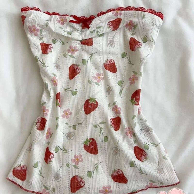 White dress with red strawberry and floral print, gathered top, and ruched straps