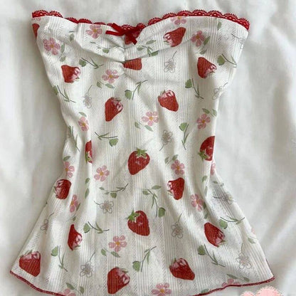 White dress with red strawberry and floral print, gathered top, and ruched straps