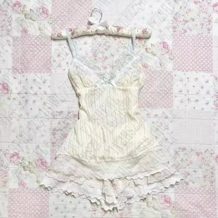 Cream satin slip dress with lace straps, lace neckline, and layered ruffled hem