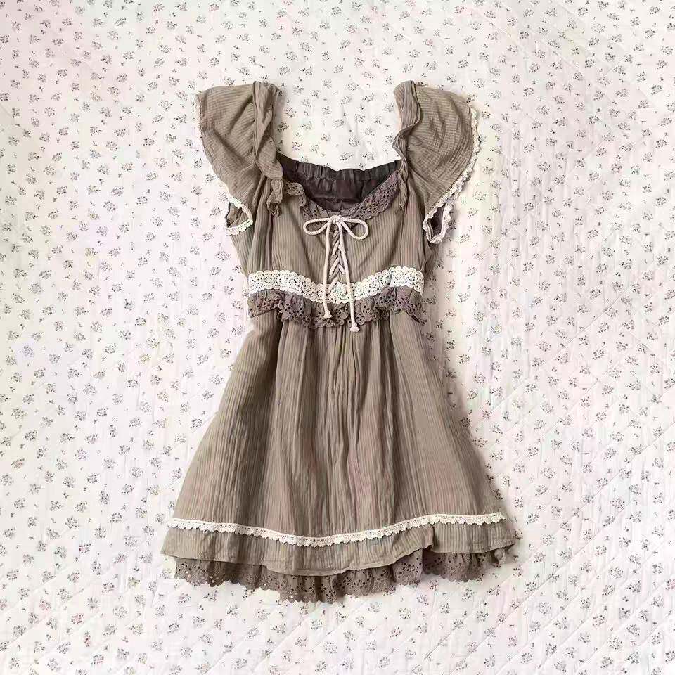Beige tiered mini dress with lace trim, puff sleeves, and ribbon tie at neckline