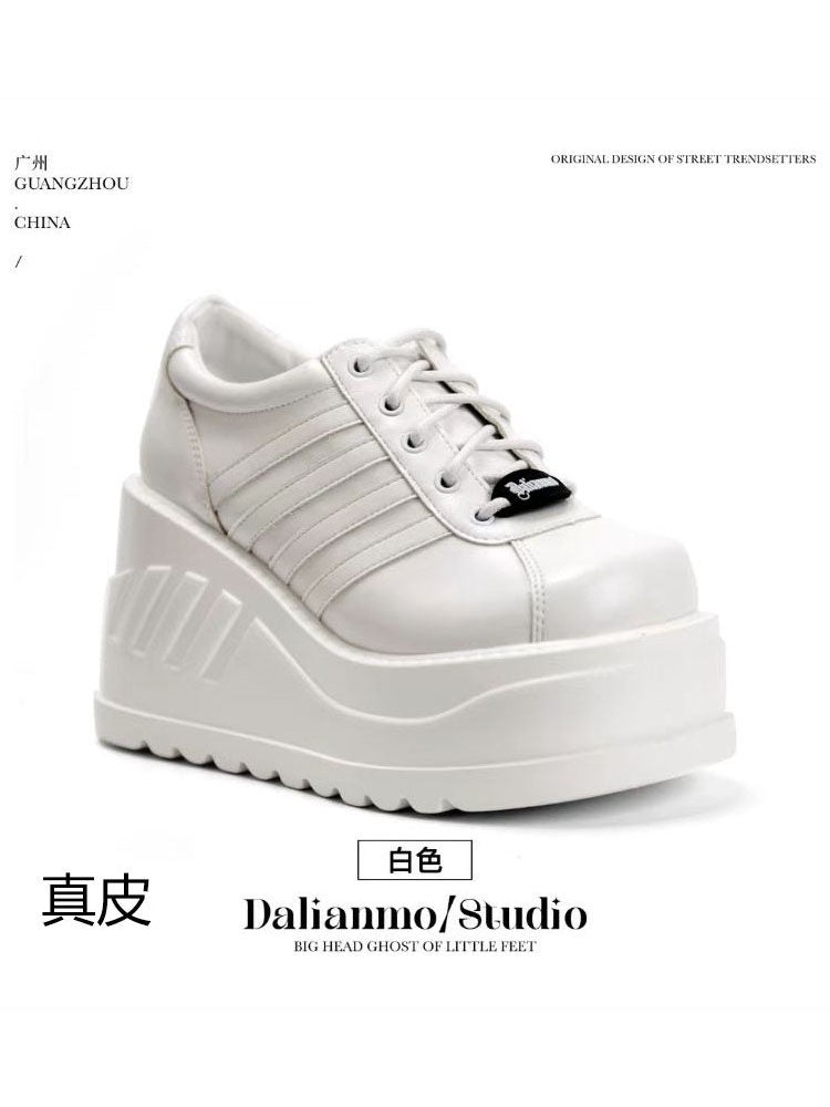 White platform shoes with lace-up front, stitched panel stripes, and thick tread sole