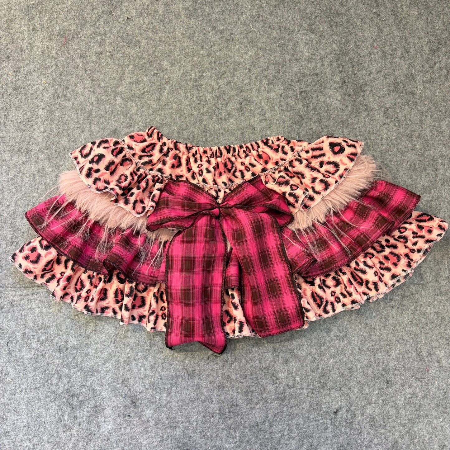 Puffy mini skirt in pink leopard and plaid layers with faux fur trim and bow