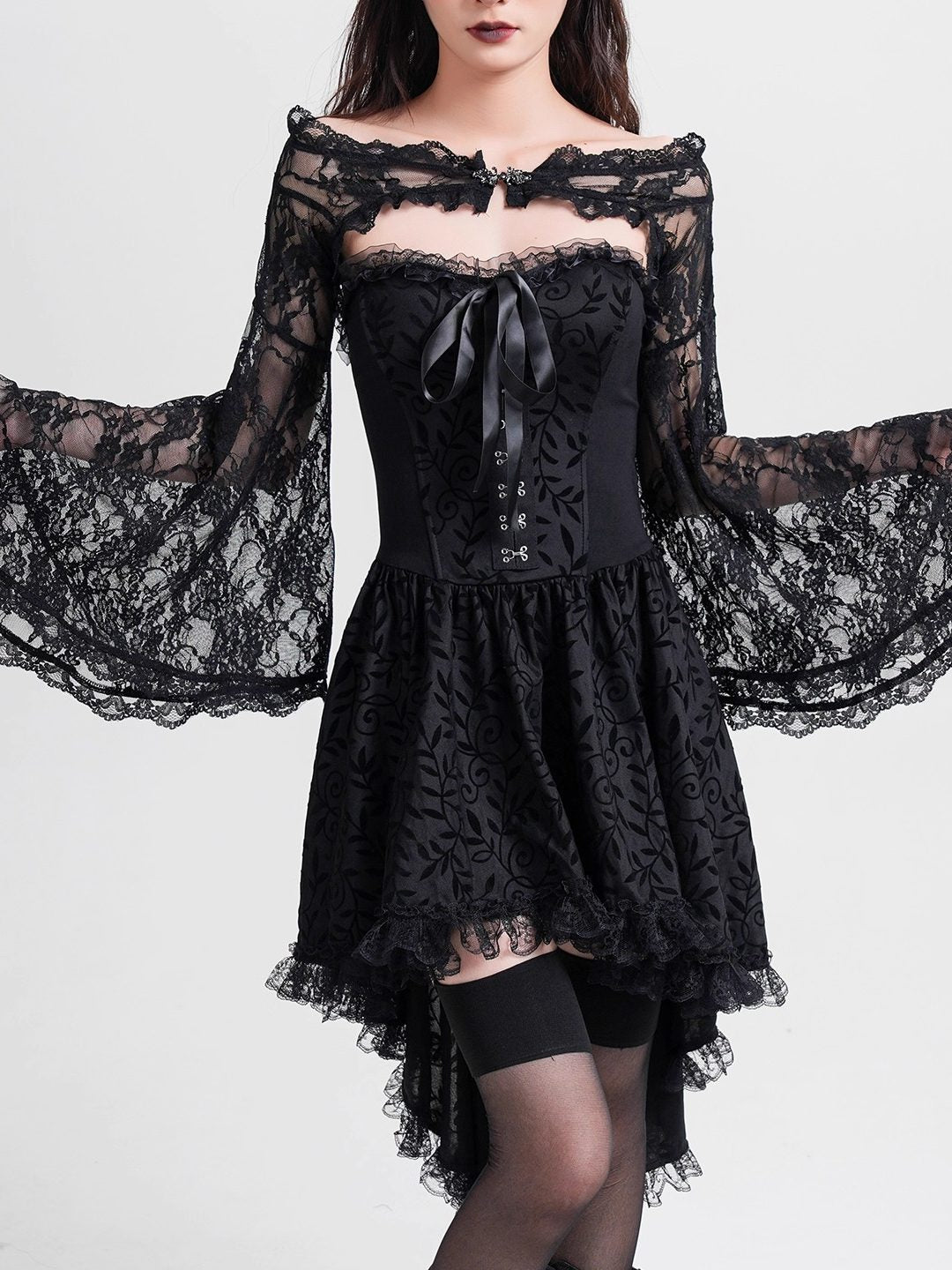 Black off-shoulder lace blouse with satin bow, long lace sleeves, and tiered hem