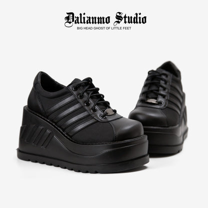 Black platform lace-up sneakers, side view, with striped panels and chunky sole