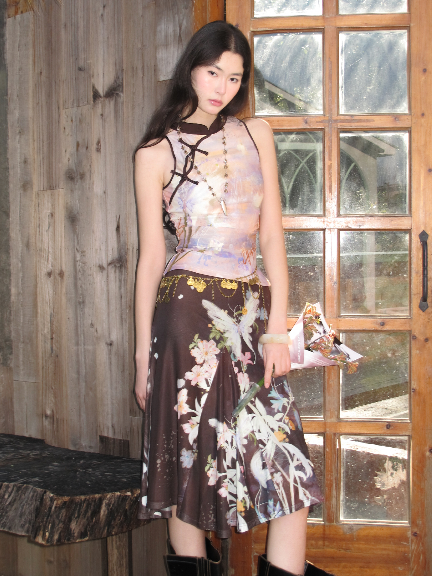 Sleeveless knit top and half skirt with black crisscross neck strap, floral butterfly print