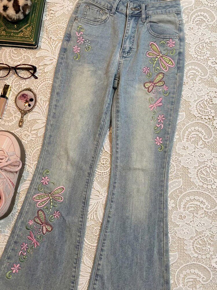 Light blue wide-leg jeans with colorful butterfly and flower embroidery along side panels.