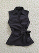 Black sleeveless cardigan top with pointed collar and button front, tied waist bow