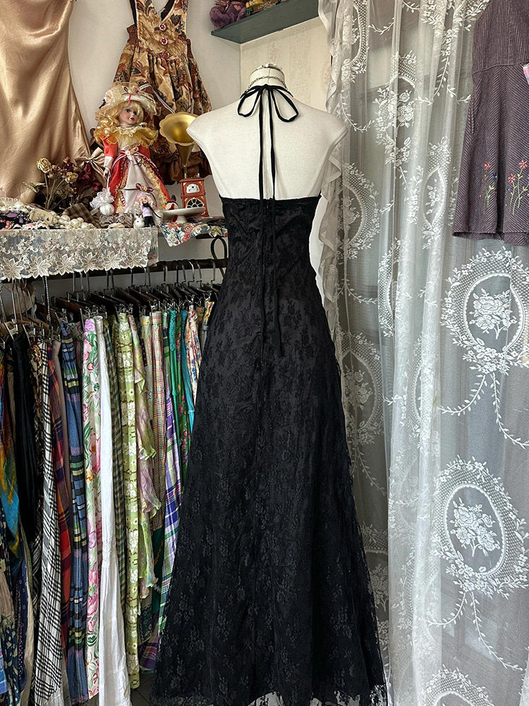 Black halterneck gown on mannequin, open-back halter ties, full skirt with gathered texture