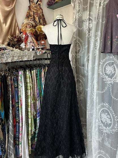 Black halterneck gown on mannequin, open-back halter ties, full skirt with gathered texture
